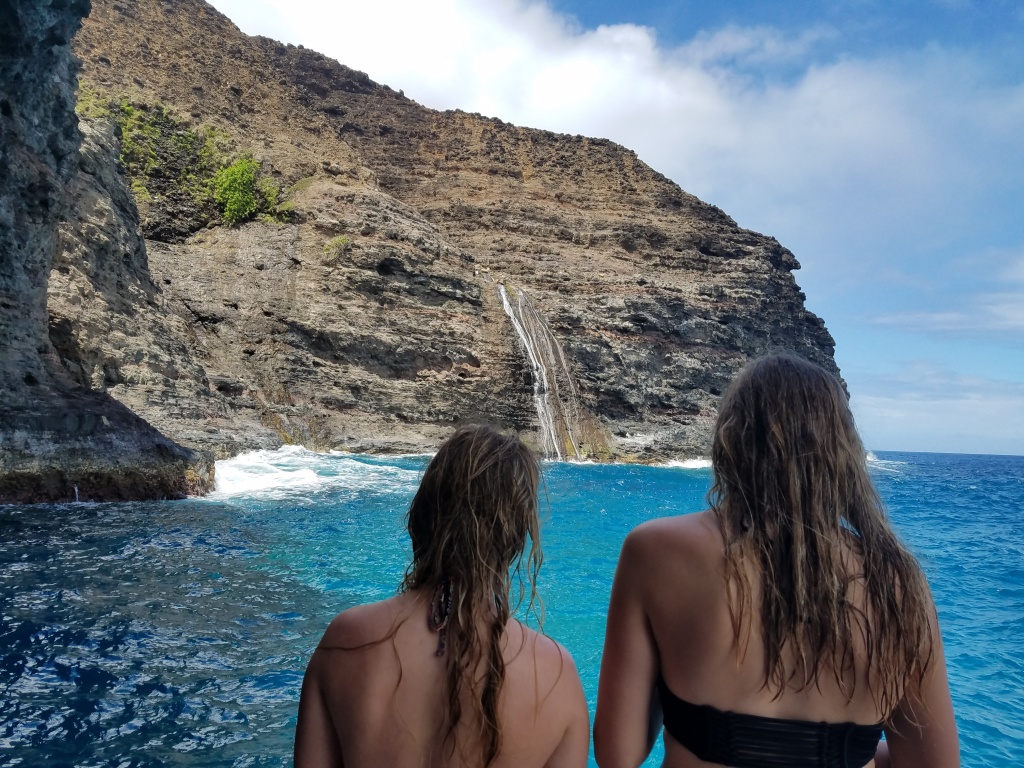 a waterfall on the na pali coast of kauai from inside a sea cave.